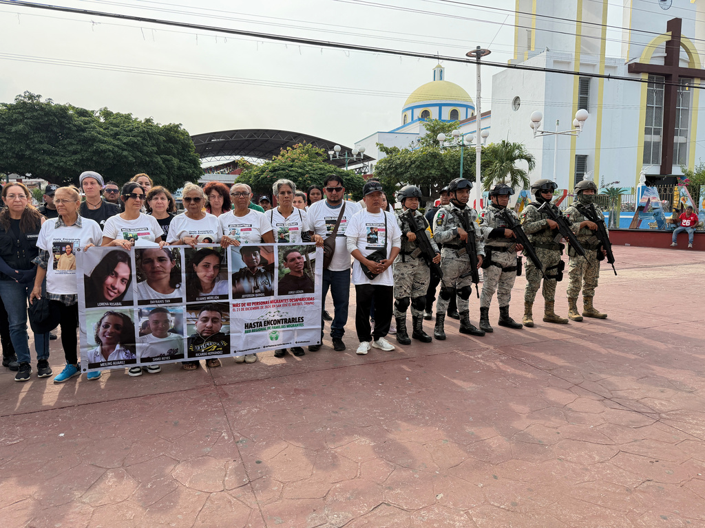 People searching for migrants who vanished in late 2024 along a maritime smuggling route to the U.S. pose with photos of their missing loved ones in Mazatan, Chiapas state, Mexico, Saturday, May 9, 2026. (AP Photo/Edgar H. Clemente)