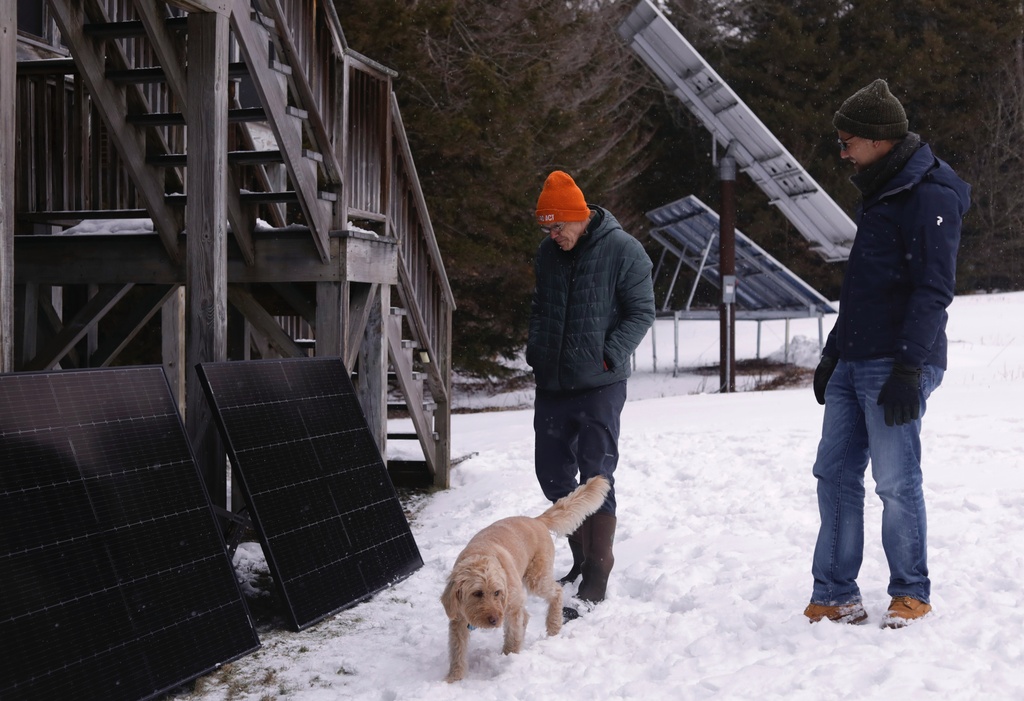 Environmentalist and author Bill Mckibben, left, discusses his new plug-in solar panel installation with Bright Saver co-founder and technical director Rupert Mayer outside his home on Monday, Jan. 12, 2026, in Ripton, Vt. (AP Photo/Amanda Swinhart)