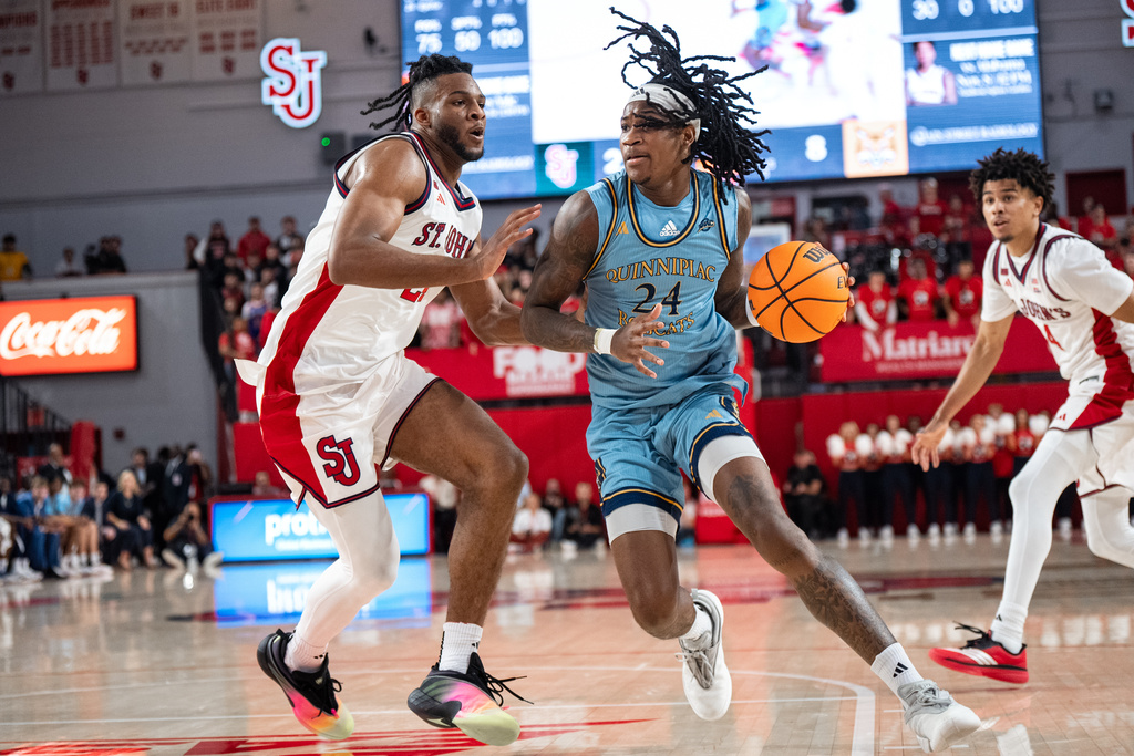Quinnipiac guard Jaden Zimmerman (24), defended by St. John's forward Zuby Ejiofor (24), heads for the basket during the first half of an NCAA college basketball game, Monday, Nov. 3, 2025, in New York. (AP Photo/Angelina Katsanis)
