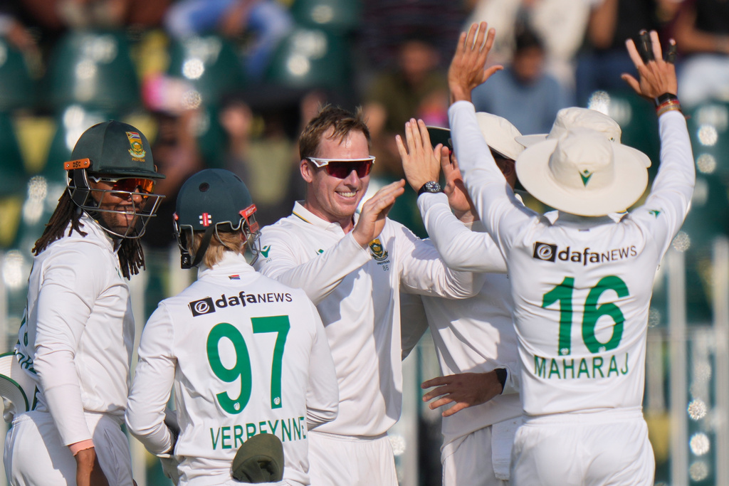 South Africa's Simon Harmer, center, celebrates with teammates after takin the wicket of Pakistan's Shan Masood during the third day of the second test cricket match between Pakistan and South Africa, in Rawalpindi, Pakistan, Wednesday, Oct. 22, 2025. (AP Photo/Anjum Naveed)