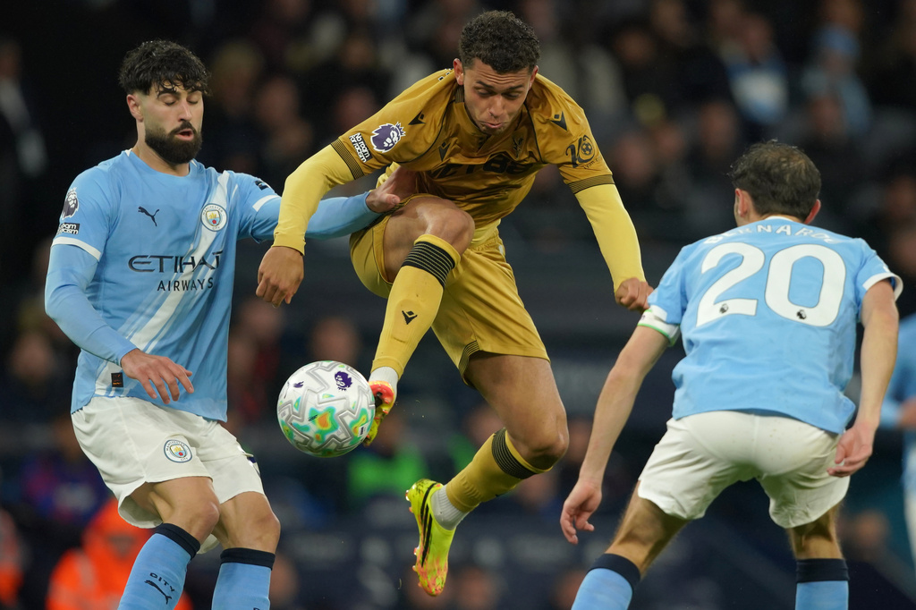 Crystal Palace's Brennan Johnson, center, challenges for the ball with Manchester City's Josko Gvardiol, left, and Manchester City's Bernardo Silva during the English Premier League soccer match between Manchester City and Crystal Palace in Manchester, England, Wednesday, May 13, 2026. (AP Photo/Ian Hodgson)