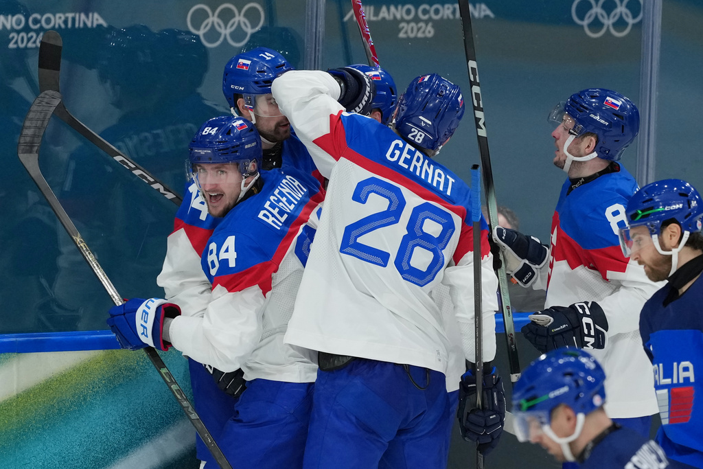 Slovakia's Adam Ruzicka, obscured behind, celebrates scoring a goal in the third period with teammates, Peter Ceresnak (14), Martin Gernat (28), Oliver Okuliar (8) and Pavol Regenda (84) during a preliminary round match of men's ice hockey between Italy and Slovakia at the 2026 Winter Olympics, in Milan, Italy, Friday, Feb. 13, 2026. (AP Photo/Carolyn Kaster)