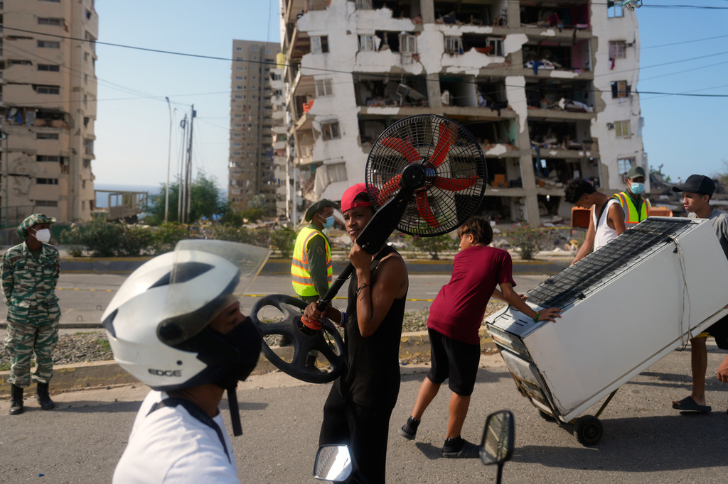 Residents recover items from homes damaged during the earthquakes in La Guaira, Venezuela, Monday, July 6, 2026. (AP Photo/Ariana Cubillos)