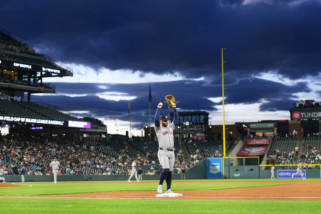 Houston Astros first baseman Christian Walker stretches as he takes his position while clouds roll in over Coors Field in the fourth inning of a baseball game against the Colorado Rockies Tuesday, April 7, 2026, in Denver. (AP Photo/David Zalubowski)