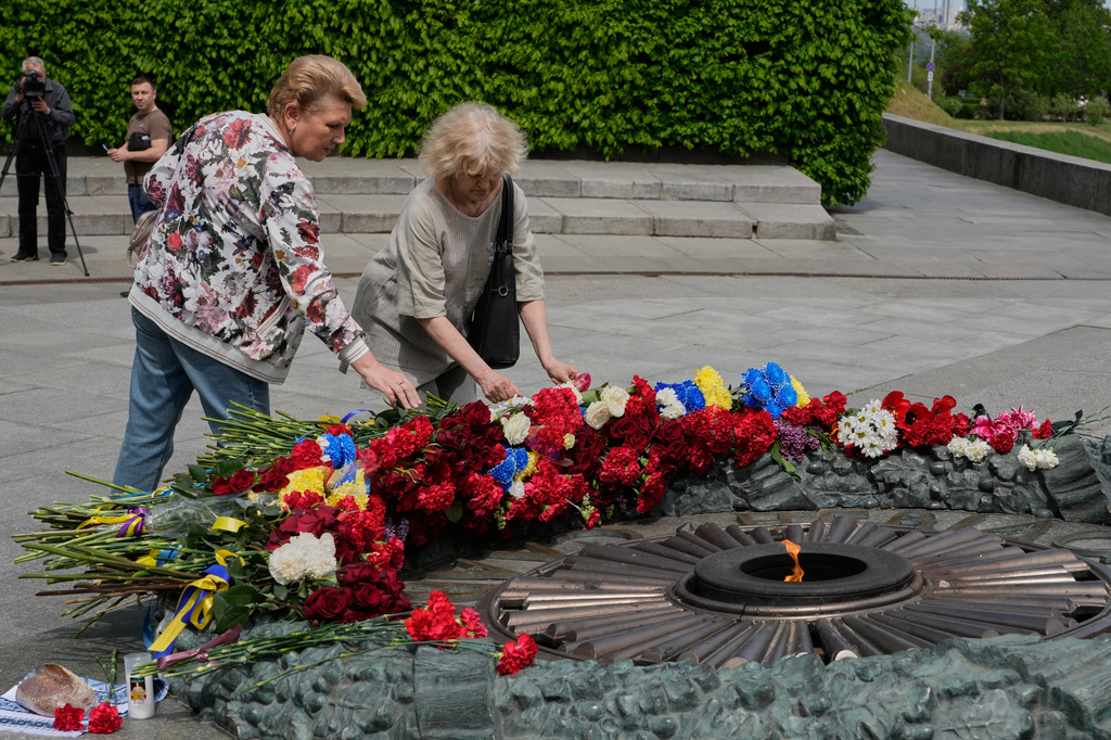 People lays flowers to the monument of the Unknown Soldier to mark Victory Day in World War II, in Kyiv, Ukraine, Tuesday, May 8, 2026. (AP Photo/Efrem Lukatsky)