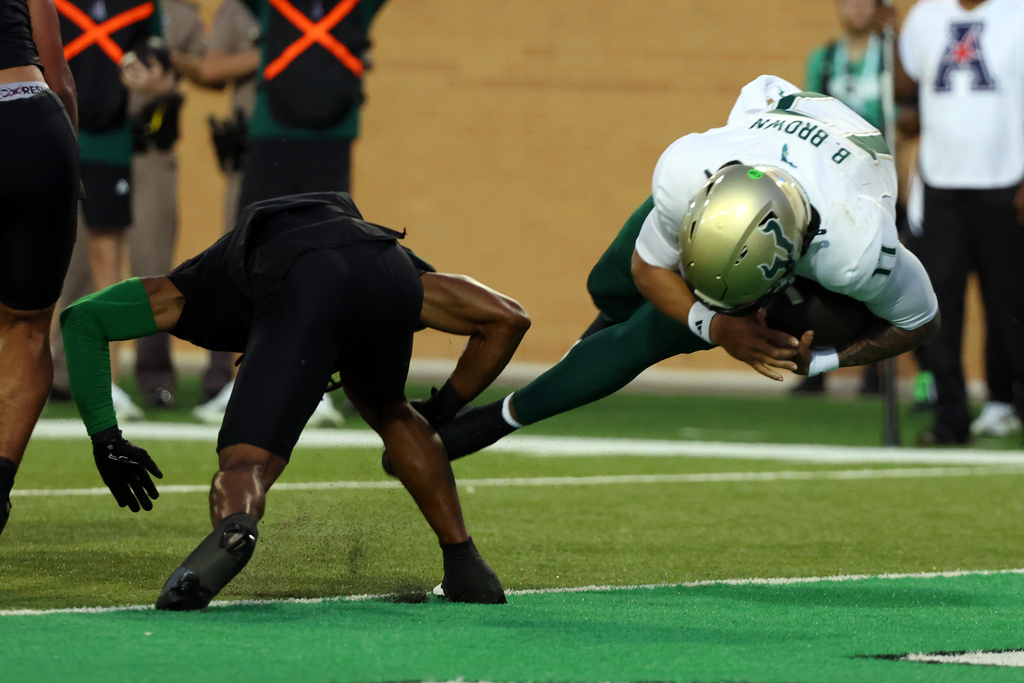 South Florida quarterback Byrum Brown, right, dives into the end zone for a first-quarter touchdown against North Texas during an NCAA college football game Friday, Oct. 10, 2025, in Denton, Texas. (AP Photo/Richard W. Rodriguez)