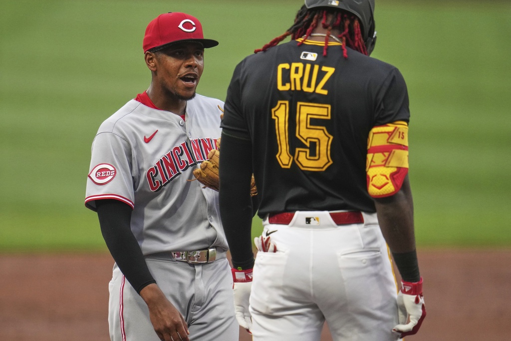Cincinnati Reds third base Ke'Bryan Hayes, left, visits with Pittsburgh Pirates' Oneil Cruz (15) who stands on third base during the first inning of a baseball game in Pittsburgh, Thursday, Aug. 7, 2025. (AP Photo/Gene J. Puskar)