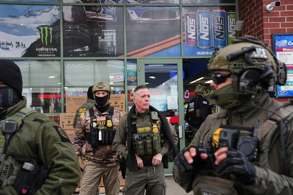 U.S. Border Patrol Cmdr. Gregory Bovino, center, and other federal immigration officers stop at a gas station Tuesday, Jan. 13, 2026, in Columbia Heights, Minn. (AP Photo/Adam Gray)
