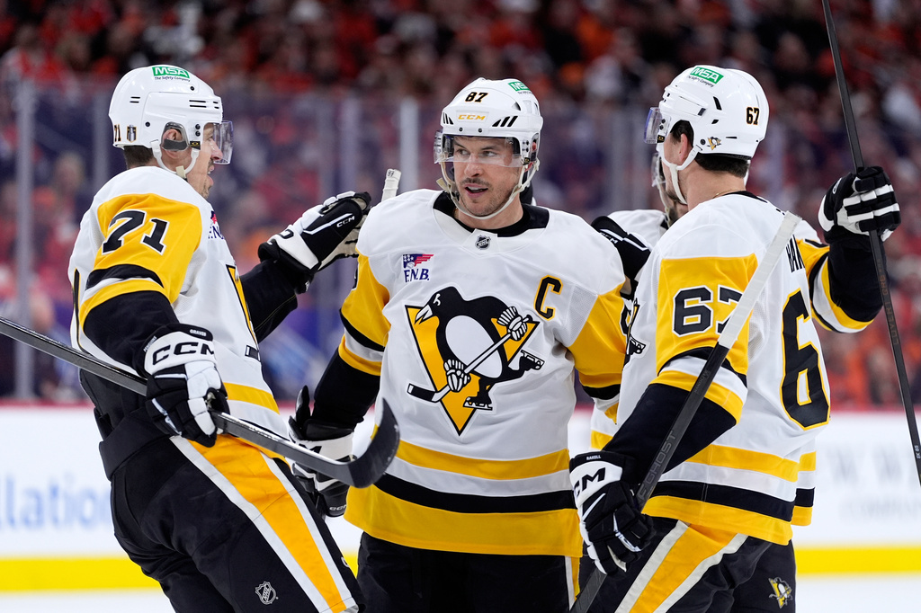 Pittsburgh Penguins' Sidney Crosby, center, celebrates with Evgeni Malkin, left, and Rickard Rakell after scoring during the first period of Game 4 against the Philadelphia Flyers in the first round of the NHL Stanley Cup hockey playoff series Saturday, April 25, 2026, in Philadelphia. (AP Photo/Matt Slocum)