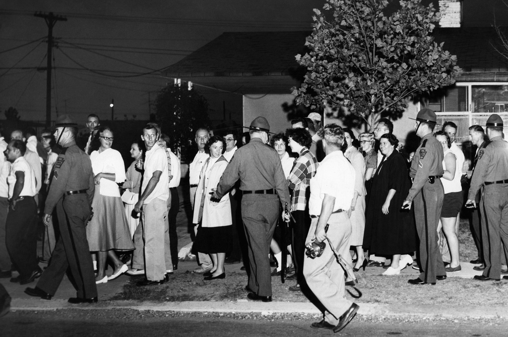 FILE - State police carrying riot sticks push back residents in Levittown, Pa., near the home of Mr. and Mrs. William Myers, the first black family to move into this planned community of previously all-white residents, Aug. 20, 1957. One man was arrested in what police said was a rock throwing in which a state trooper was struck. (AP Photo/Sam Myers, File)