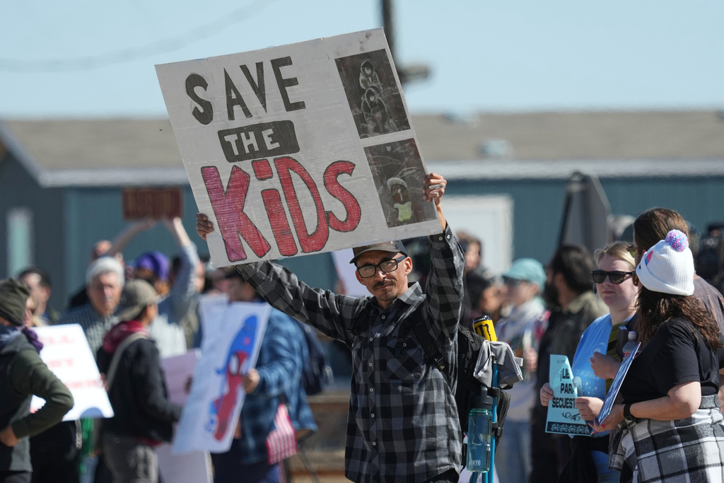 FILE - Protesters gather outside the South Texas Family Residential Center detention facility where Liam Ramos and his father are being detained in Dilley, Texas, Wednesday, Jan. 28, 2026. (AP Photo/Eric Gay, File)