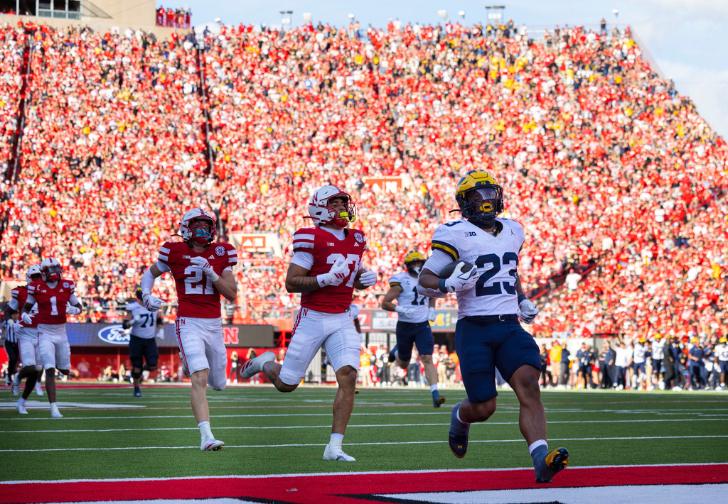 Michigan's Jordan Marshall, right, runs in a touchdown ahead of Nebraska's Rex Guthrie, left, and Donovan Jones during the second half of an NCAA college football game Saturday, Sept. 20, 2025, in Lincoln, Neb. (AP Photo/Rebecca S. Gratz)