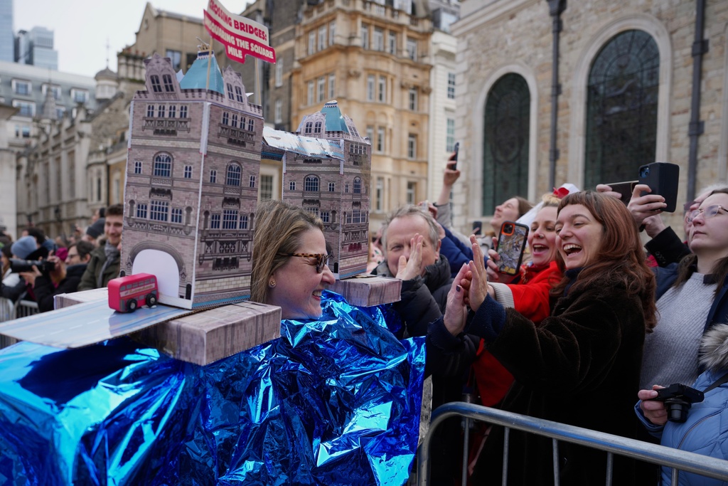 A competitor participates in a traditional pancake race by livery companies at the Guildhall in London, Tuesday, Feb. 17, 2026. (AP Photo/Kin Cheung)