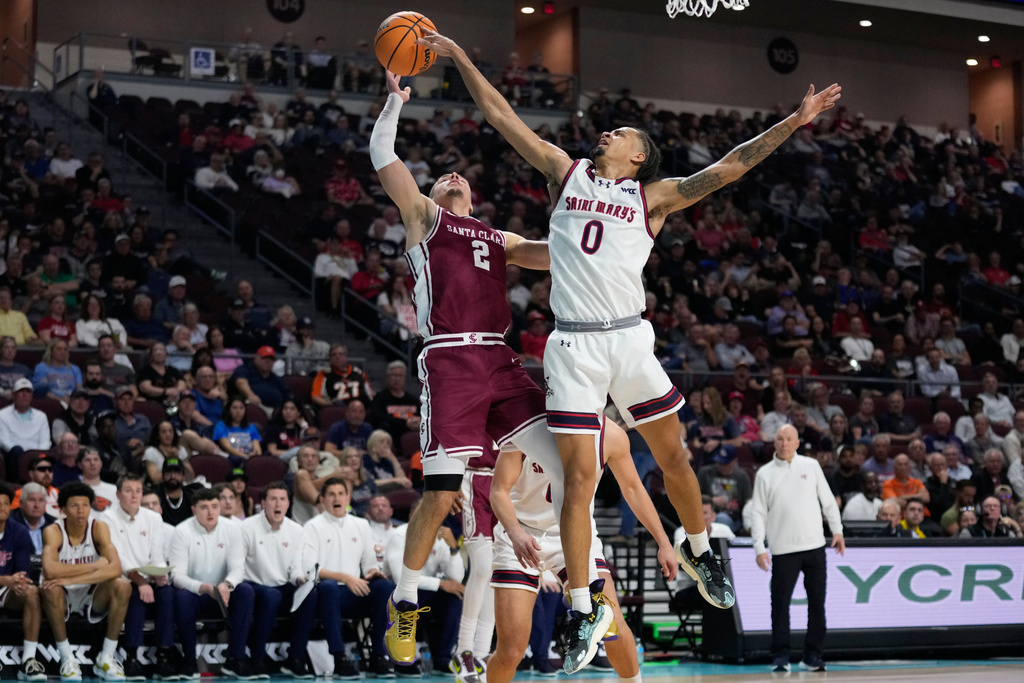 Saint Mary's guard Mikey Lewis (0) blocks a shot attempt by Santa Clara guard Sash Gavalyugov (2) during the first half of an NCAA college basketball semifinal game in the West Coast Conference men's tournament Monday, March 9, 2026, in Las Vegas. (AP Photo/John Locher)