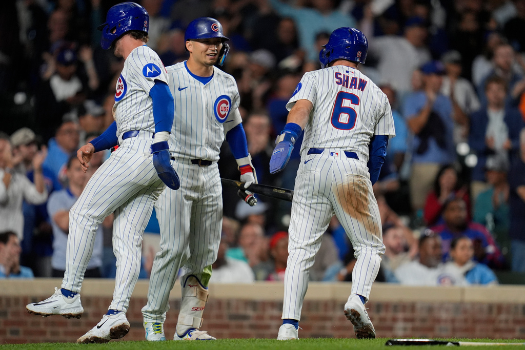 From left, Chicago Cubs' Nico Hoerner (2), Seiya Suzuki (27) and Matt Shaw (6) celebrate Ian Happ (8)'s two-run double during the second inning of a baseball game against the New York Mets, Tuesday, Sept. 23, 2025, in Chicago. (AP Photo/Erin Hooley)