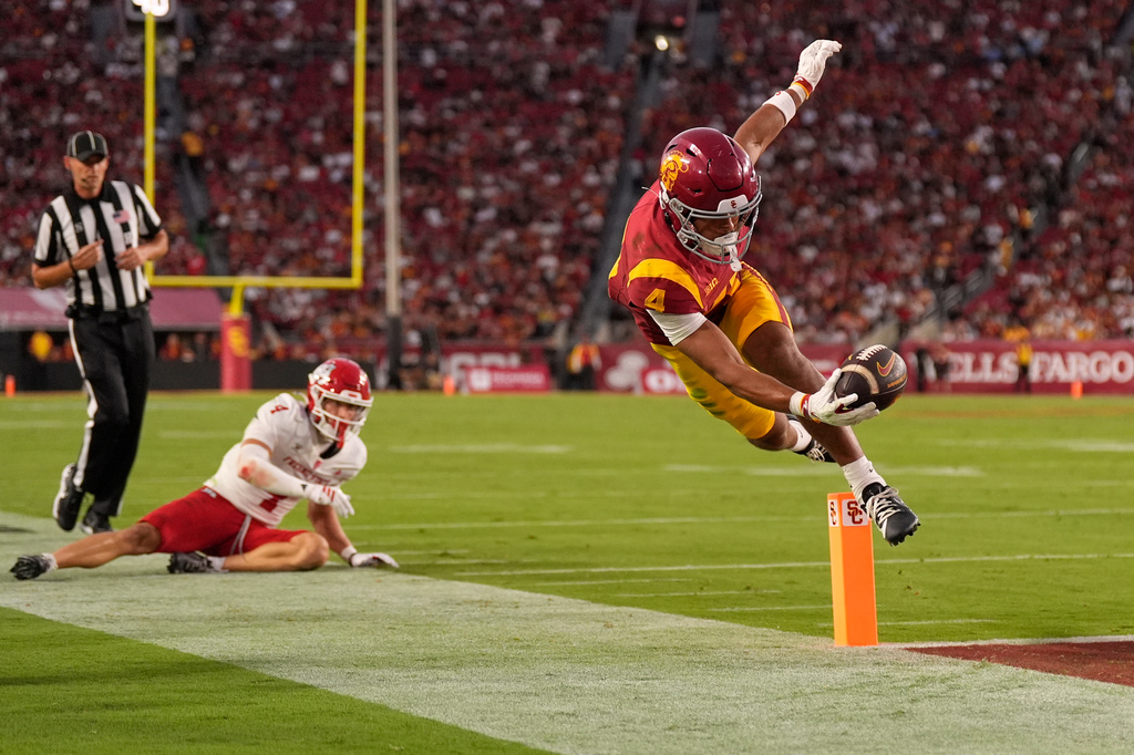 Southern California wide receiver Trent Mosley, right, scores a touchdown as Fresno State defensive back Ethan Tierney watches during the first half of an NCAA college football game, Friday, Sept. 4, 2026, in Los Angeles. (AP Photo/Mark J. Terrill)
