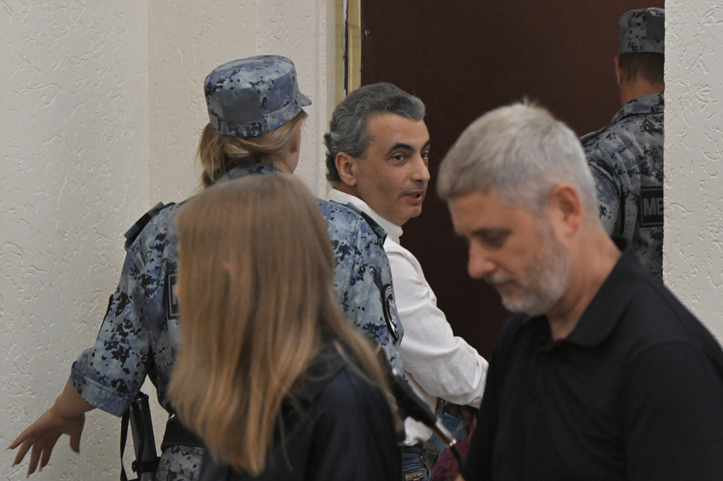 Lev Shlosberg, center, senior member of the Yabloko party, is being led out of the court room after a judge convicted him and sentenced him to more than 11 years in prison, in a court in Pskov, Russia, Monday, Aug. 17, 2026. (AP Photo)