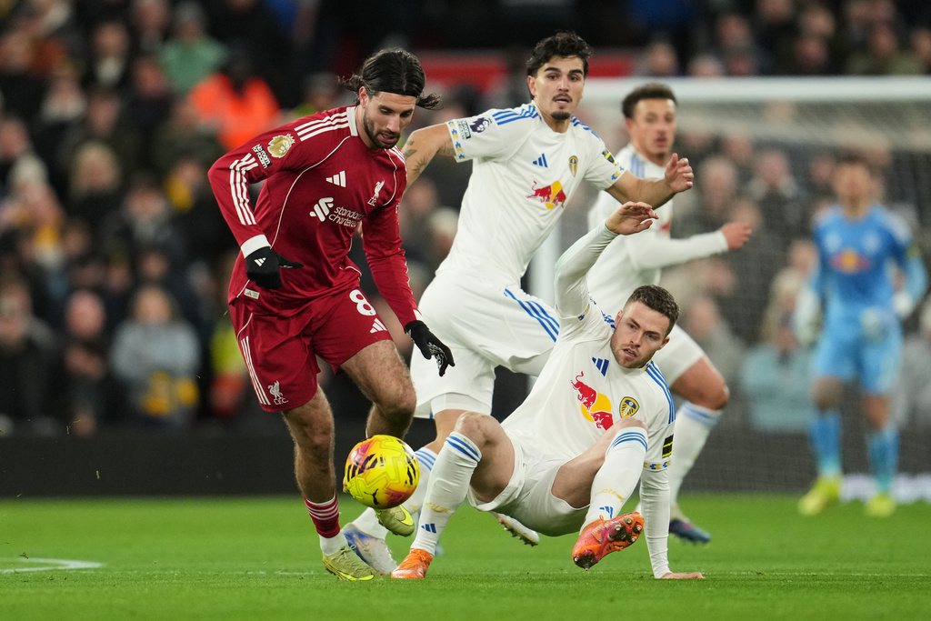 Liverpool's Dominik Szoboszlai, left, and Leeds' Gabriel Gudmundsson challenge for the ball during the English Premier League soccer match between Liverpool and Leeds United in Liverpool, England, Thursday, Jan. 1, 2026. (AP Photo/Jon Super)