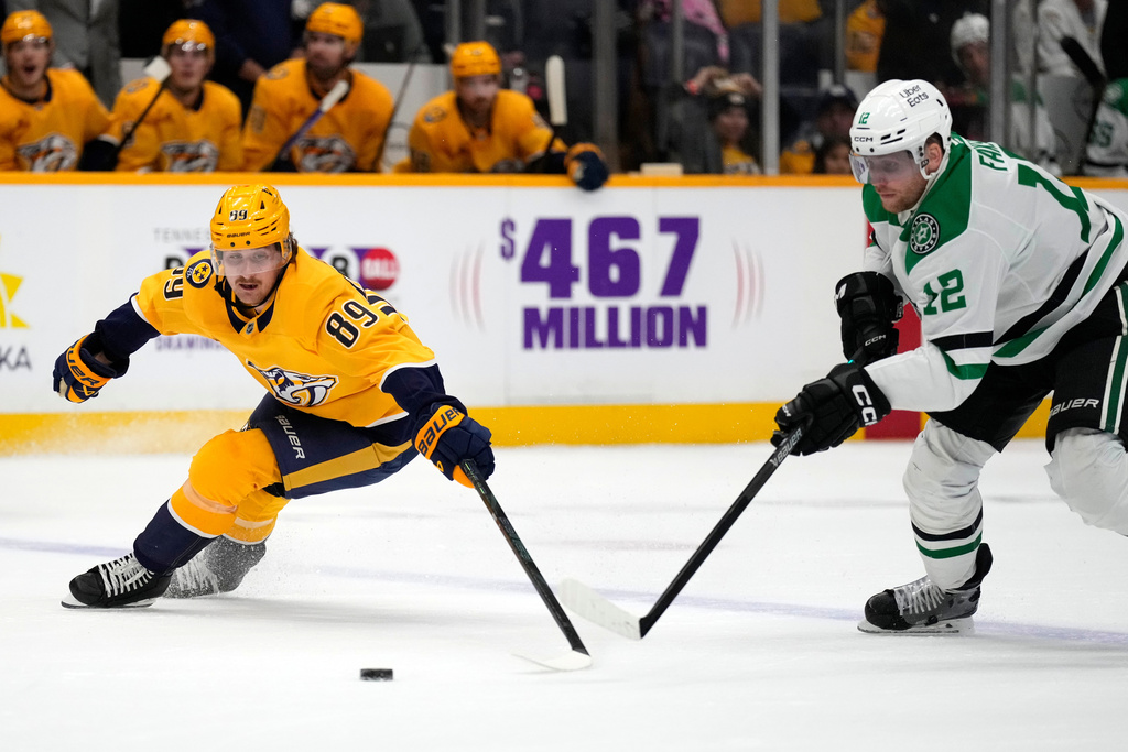 Nashville Predators right wing Ozzy Wiesblatt (89) chases the puck with Dallas Stars center Radek Faksa (12) during the second period of an NHL hockey game Saturday, Nov. 8, 2025, in Nashville, Tenn. (AP Photo/Mark Humphrey)