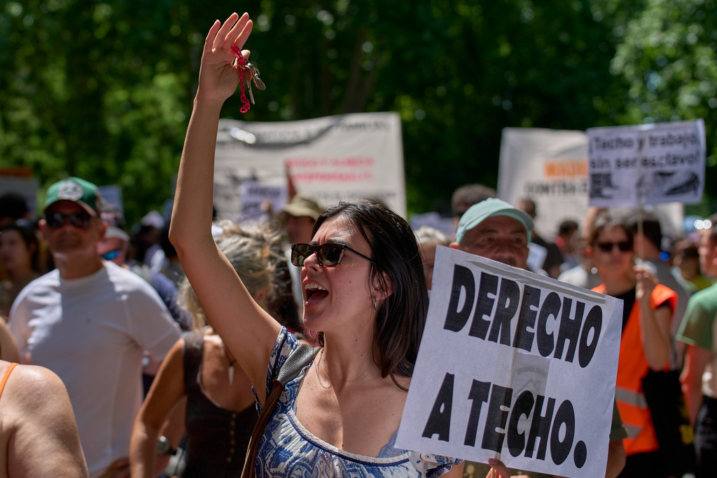 A woman holds a banner reading in Spanish: "Right to housing" during a protest in Madrid, Spain, Sunday, May 24, 2026, against rising housing costs that are pricing many Spaniards out of the market amid Spain's broader housing crisis. (AP Photo/Manu Fernandez)
