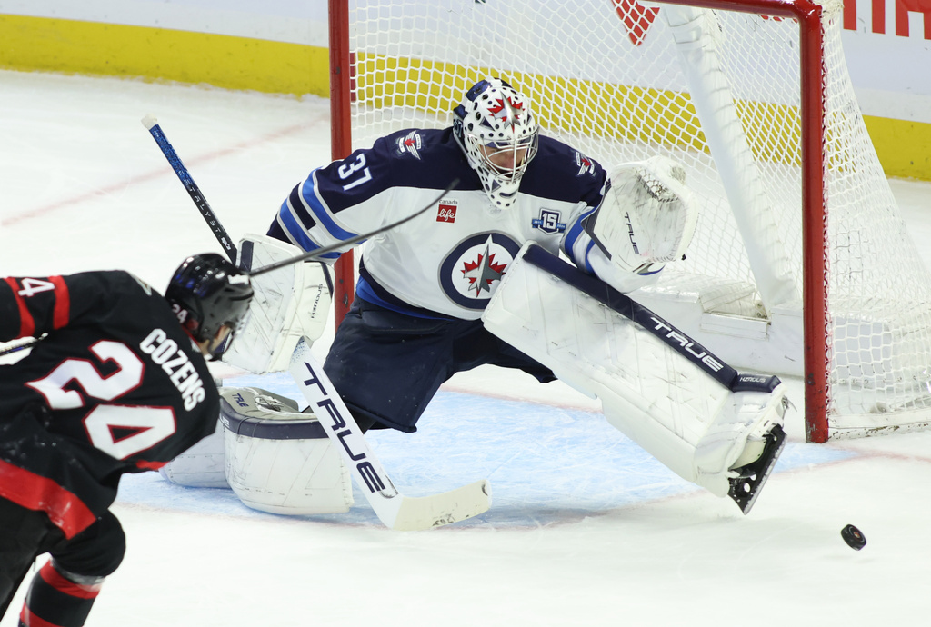 Winnipeg Jets goaltender Connor Hellebuyck (37) makes a save on a shot by Ottawa Senators' Dylan Cozens (24) during the second period of an NHL hockey game in Ottawa, Ontario, on Saturday, Jan. 3, 2026. (Patrick Doyle/The Canadian Press via AP)