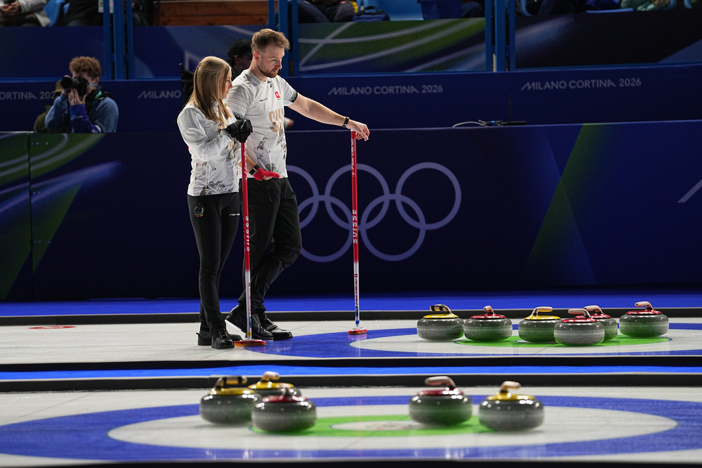 Switzerland's Briar Schwaller-Huerlimann and Yannick Schwaller look at the stones, during the mixed doubles round robin phase of the curling competition against Estonia, at the 2026 Winter Olympics, in Cortina d'Ampezzo, Italy, Wednesday, Feb. 4, 2026. (AP Photo/Fatima Shbair)