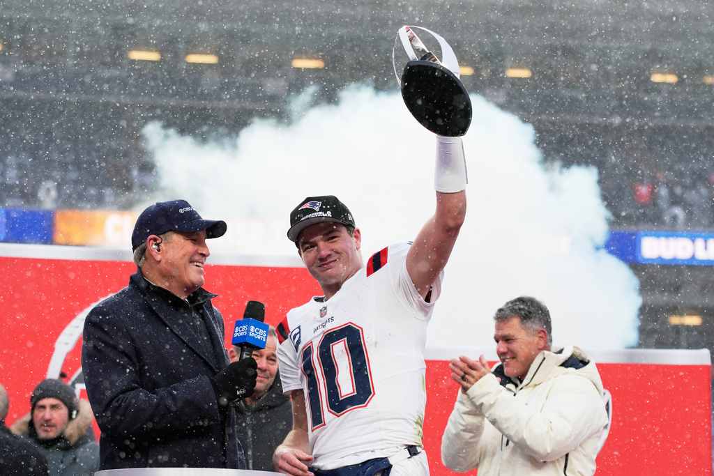 New England Patriots quarterback Drake Maye celebrates with the trophy after the AFC Championship NFL football game between the Denver Broncos and the New England Patriots, Sunday, Jan. 25, 2026, in Denver. (AP Photo/John Locher)