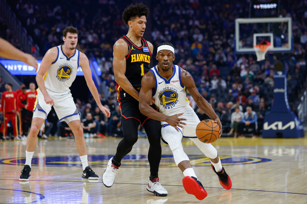 Golden State Warriors Jimmy Butler III (10) dribbles the ball past Atlanta Hawks Jalen Johnson (1) during the first half an an NBA basketball game in San Francisco, Sunday, Jan. 11, 2026. (Carlos Avila Gonzalez/San Francisco Chronicle via AP)
