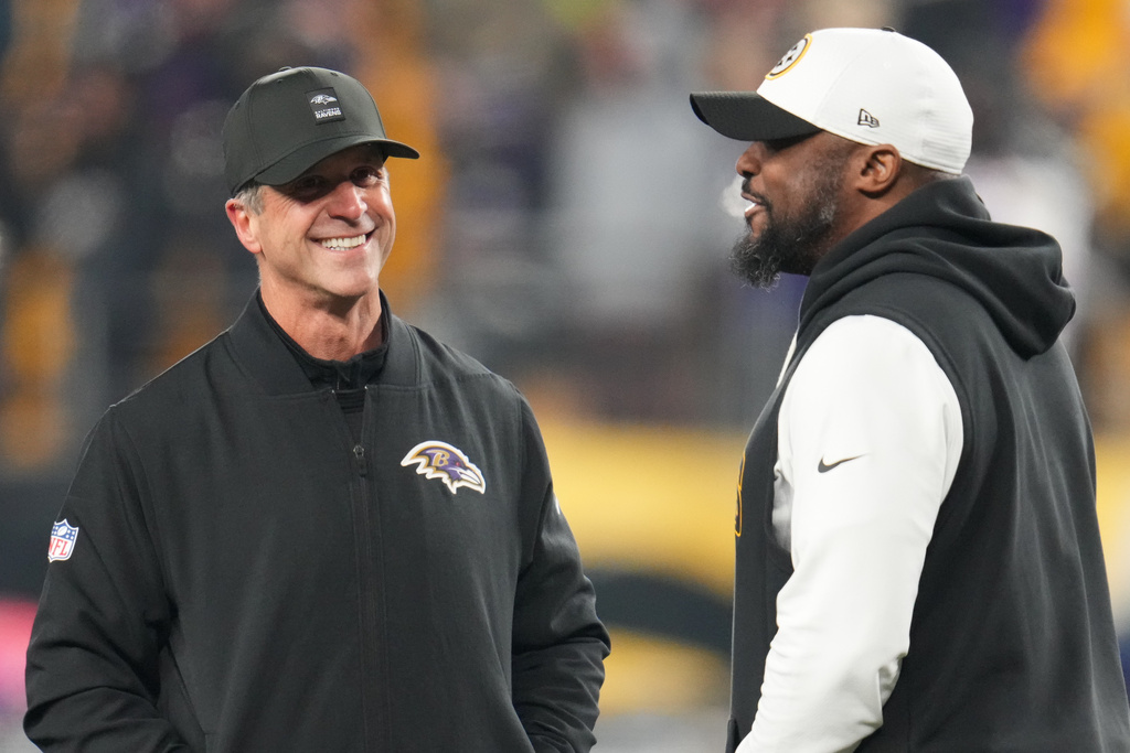 Baltimore Ravens head coach John Harbaugh, left, and Pittsburgh Steelers head coach Mike Tomlin, right, talk before an NFL football game Sunday, Jan. 4, 2026, in Pittsburgh. (AP Photo/Gene J. Puskar)