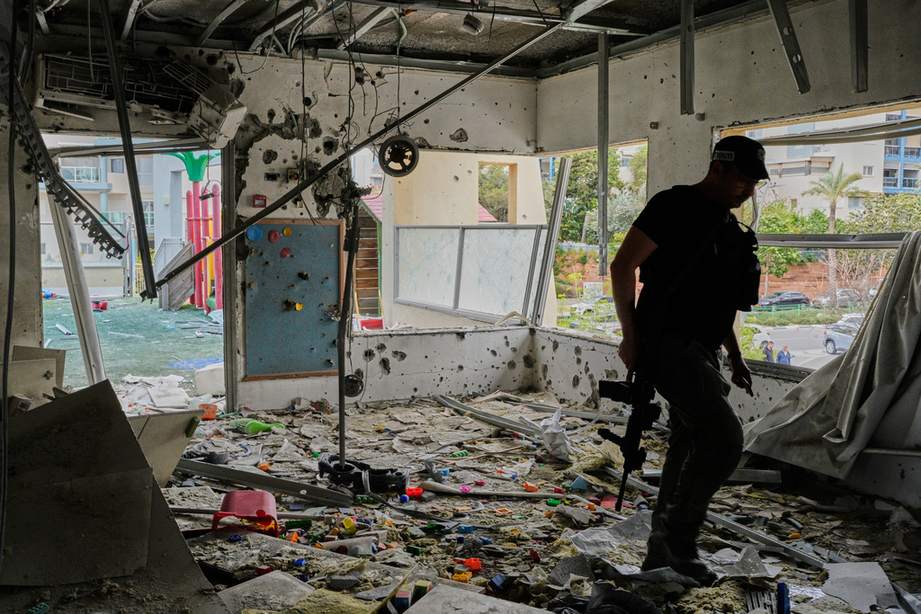 An Israeli policeman walks in a kindergarten hit by fragments of an Iranian missile in Rishon LeZion, Israel, Saturday, March 21, 2026. (AP Photo/Maya Levin)