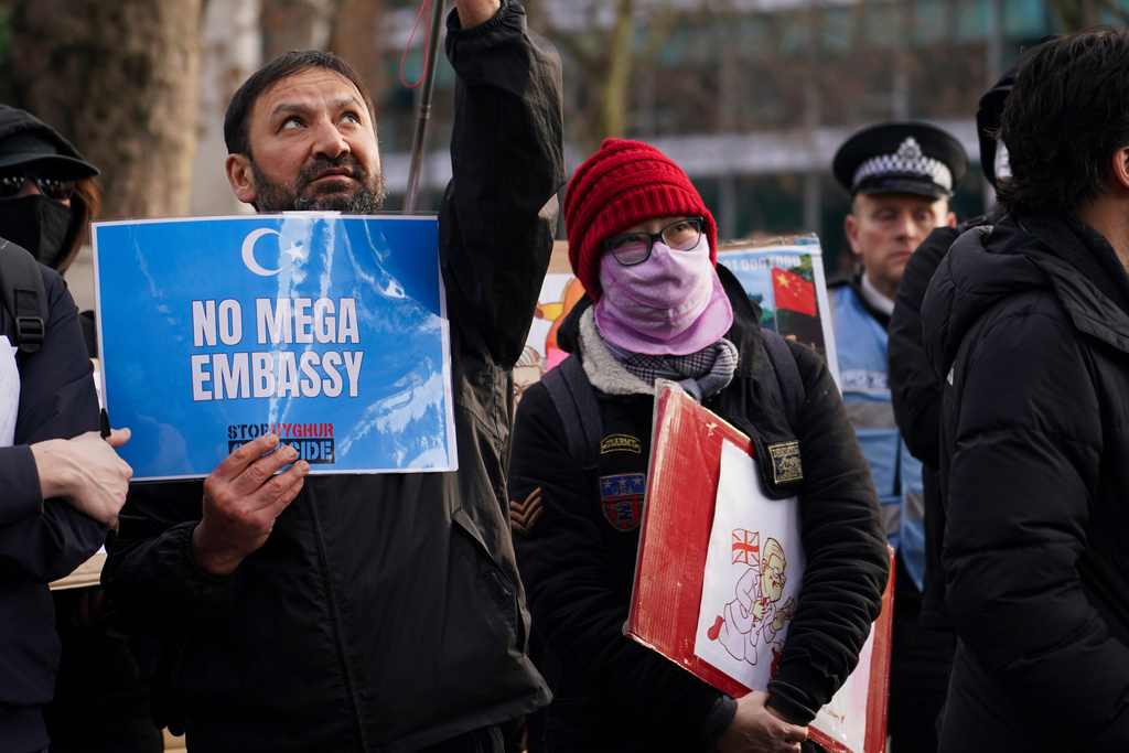 Demonstrators hold placards and flags as they attend a protest against the proposed Chinese embassy, in London, Saturday, Jan. 17, 2026. (AP Photo/Alberto Pezzali)