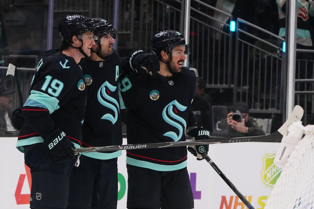 Seattle Kraken center Matty Beniers, second from left, celebrates his goal against the Minnesota Wild with left wing Jared McCann (19) and center Frederick Gaudreau, right, during the third period of an NHL hockey game Thursday, Jan. 8, 2026, in Seattle. (AP Photo/Lindsey Wasson)