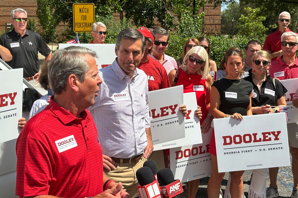 Georgia Gov. Brian Kemp, left, speaks accompanied by Republican U.S. Senate candidate Derek Dooley, second left, at the University of Georgia in Athens, Ga., on Saturday, Aug. 30, 2025. (AP Photo/Jeff Amy)