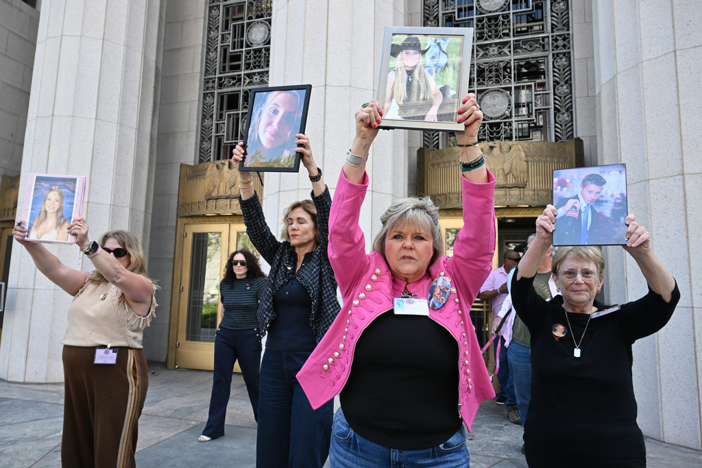 Lori Schott, second from right, holds up a photo of her daughter Annalee Schott, beside others after the verdict in a landmark trial over whether social media platforms deliberately addict and harm children at Los Angeles Superior Court, Wednesday, March 25, 2026, in Los Angeles. (AP Photo/William Liang)