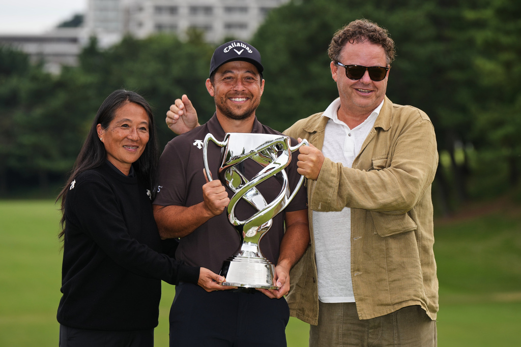 Xander Schauﬀele, of the U.S., poses for a photo with his parents, Chen Ping-Yi, left, and Stefan Schauffele, as he won the Baycurrent Classic golf tournament at the Yokohama Country Club in Yokohama, near Tokyo, Sunday, Oct. 12, 2025. (AP Photo/Hiro Komae)