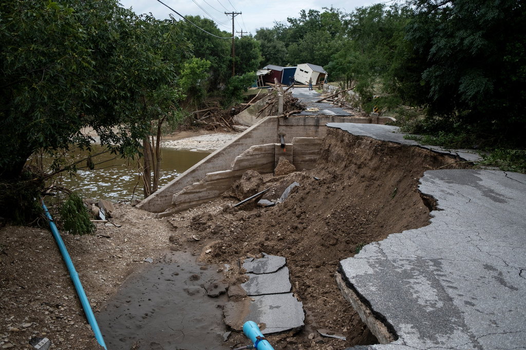 A partially-collapsed bridge crossing Goat Creek is damaged following floods near the Guadalupe River on Friday, July 17, 2026, in Kerrville, Texas. (AP Photo/Joel Angel Juarez)