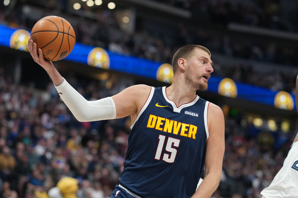 Denver Nuggets center Nikola Jokić pulls in a loose ball in the first half of an NBA basketball game against the Memphis Grizzlies Wednesday, April 8, 2026, in Denver. (AP Photo/David Zalubowski)