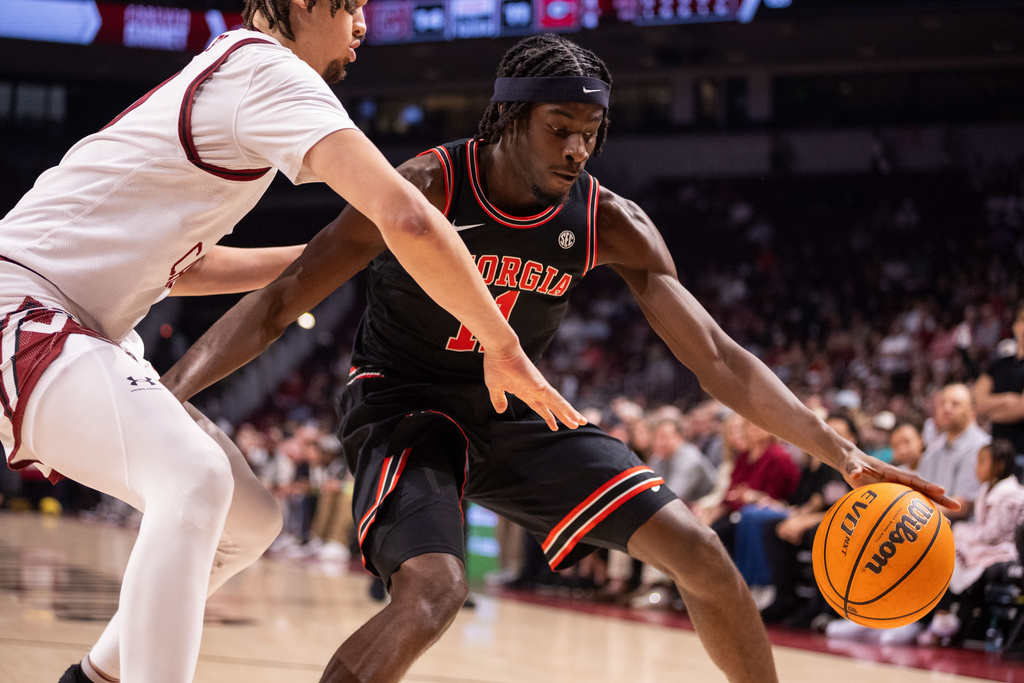 Georgia forward Dylan James (11) is guard by South Carolina forward Hayden Assemian (20) during the first half of an NCAA college basketball game Saturday, Jan. 10, 2026, in Columbia, S.C. (AP Photo/Scott Kinser)