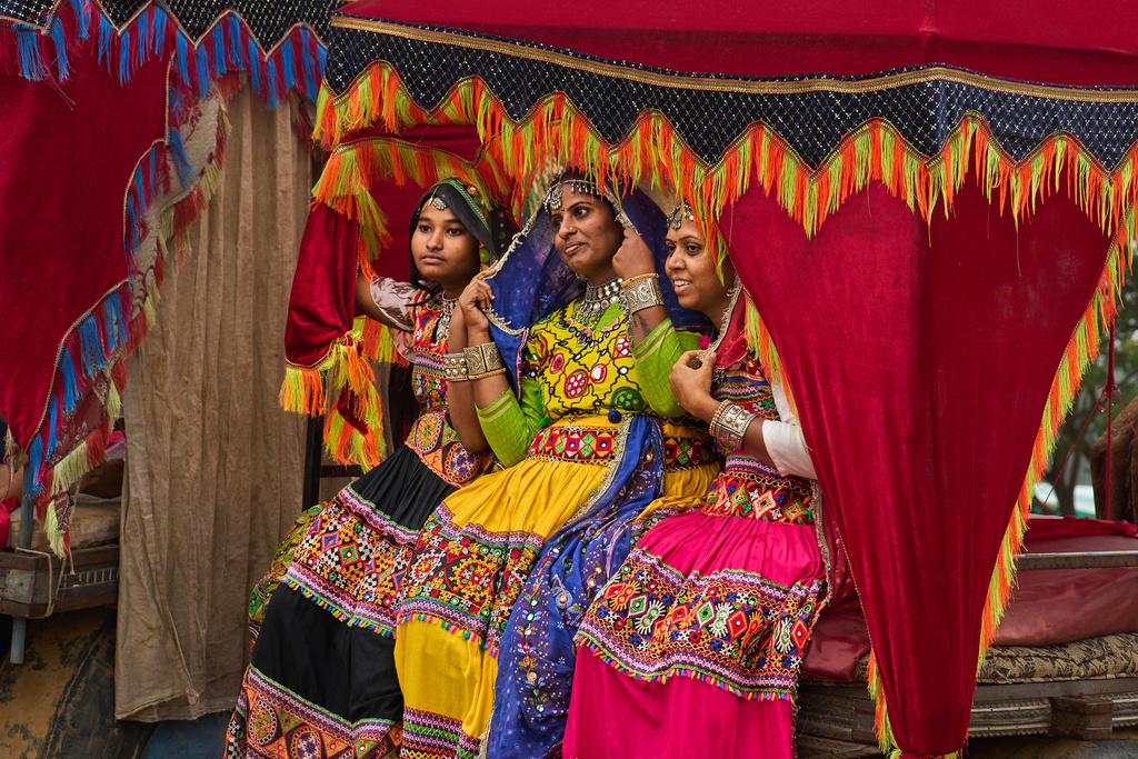 Indian tourists pose for a photograph while sitting on a decorated camel cart at the annual Pushkar cattle fair, in the western state of Rajasthan, Monday, Oct. 27, 2025. (AP Photo/Rajesh Kumar Singh)