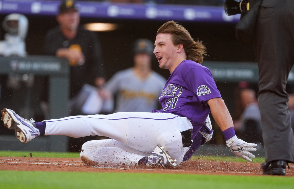 Colorado Rockies' Jake McCarthy slides safely across home plate to notch an inside-the-park home run off Pittsburgh Pirates starting pitcher Paul Skenes in the first inning of a baseball game Saturday, June 20, 2026, in Denver. (AP Photo/David Zalubowski)