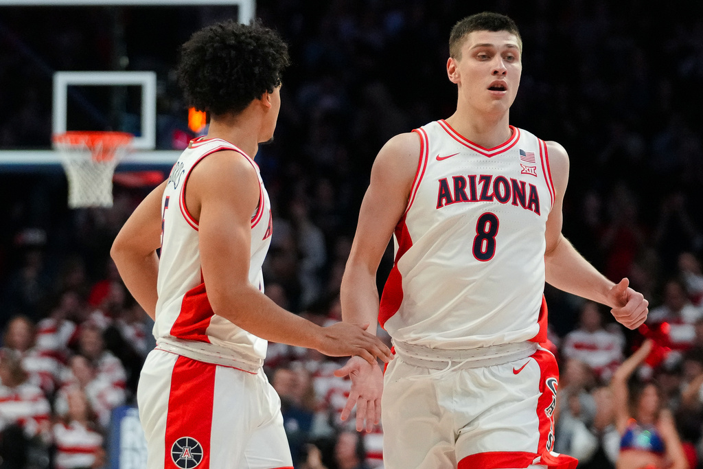 Arizona Wildcats guard Brayden Burries, left, slaps hands with Ivan Kharchenkov (8) during the first half of an NCAA college basketball game against Denver, Monday, Nov. 24, 2025, in Tucson, Ariz. (AP Photo/Darryl Webb)