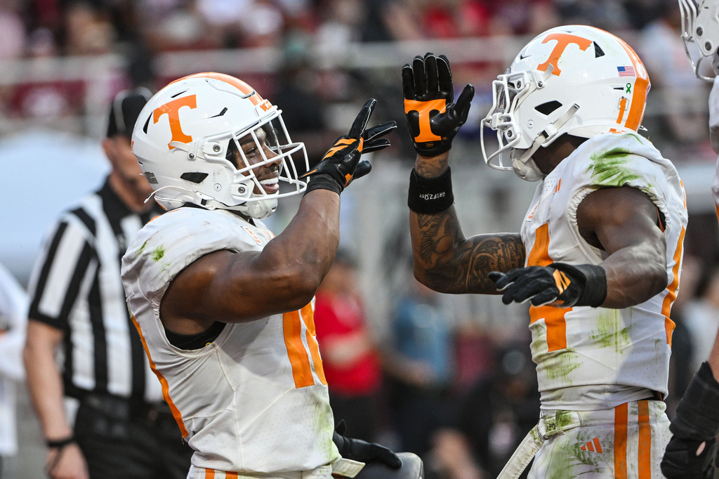 Tennessee running back DeSean Bishop, left, celebrates with teammate Braylon Staley, right, after running for a touchdown against Arkansas during the second half of an NCAA college football game Saturday, Oct. 10, 2026, in Fayetteville, Ark. (AP Photo/Michael Woods)