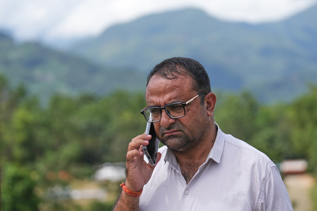 Rajendra Dawadi, a school teacher of Tribhuvan Trishuli Secondary School, talks on his mobile phone in Trishuli Valley in Nepal's Nuwakot district, Monday, Aug. 31, 2026. (AP Photo/Rajesh Kumar Singh)