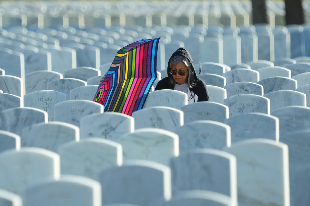 Norma Like visits the gravesite of her husband before a Veteran's Day observance at the Fort Sam Houston National Cemetery in San Antonio, Tuesday, Nov. 11, 2025. (AP Photo/Eric Gay)