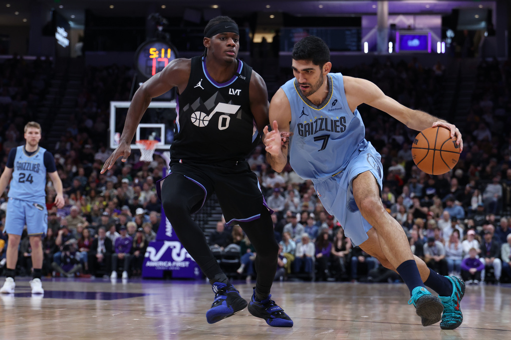 Memphis Grizzlies forward Santi Aldama (7) drives to the basket against Utah Jazz forward Taylor Hendricks (0) during the first half of an NBA basketball game, Tuesday, Dec. 23, 2025, in Salt Lake City. (AP Photo/Rob Gray)