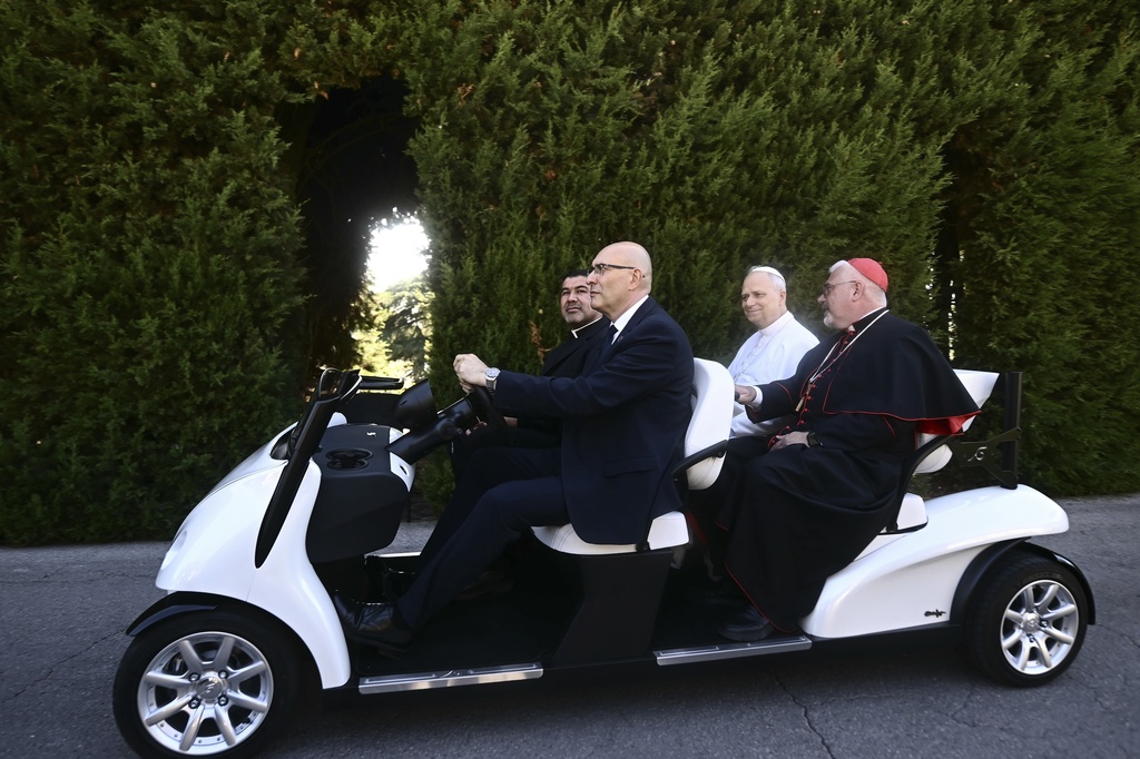 Pope Leo XIV, second from right, sits on an electric car during a tour for the inauguration of the "Borgo Laudato Si'" Advanced Training Center, at the papal summer residence in Castel Gandolfo, Italy, Friday Sept. 5, 2025. (Filippo Monteforte, Pool via AP)