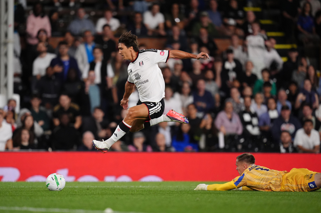 Fulham's Gonzalo Garcia, left, gets past the AFC Wimbledon goalkeeper Nathan Bishop to score their third goal of the game during the League Cup soccer match between Fulham and AFC Wimbledon in London, Thursday, Aug. 27, 2026. (John Walton/PA via AP)