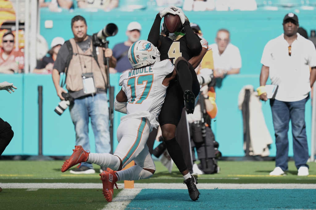New Orleans Saints cornerback Kool-Aid McKinstry (4) intercepts a pass in the end zone intended for Miami Dolphins wide receiver Jaylen Waddle (17) during the first half of an NFL football game Sunday, Nov. 30, 2025, in Miami Gardens, Fla. (AP Photo/Rebecca Blackwell)