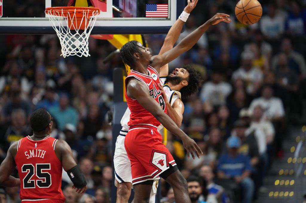 Chicago Bulls forward Caleb Wilson, front right, blocks a shot by Denver Nuggets guard Jamal Murray, back right, as Chicago center Jalen Smith covers in the first half of a preseason NBA basketball game Sunday, Oct. 11, 2026, in Denver. (AP Photo/David Zalubowski)