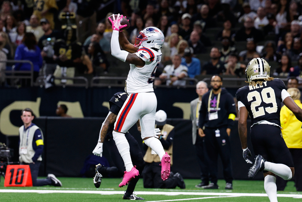New England Patriots wide receiver Kayshon Boutte, left, catches a ball before running for a touchdown against New Orleans Saints cornerback Quincy Riley during the first half of an NFL football game, Sunday, Oct. 12, 2025, in New Orleans. (AP Photo/Butch Dill)